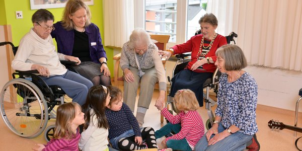 Kindergartenkinder und Senioren musizieren gemeinsam.