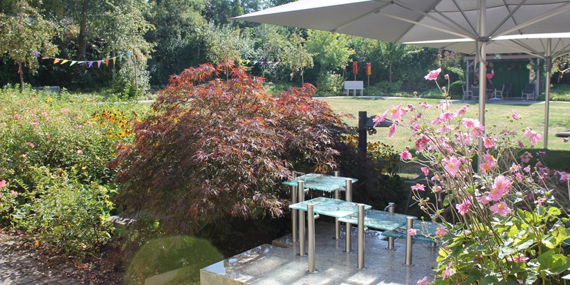 Gepflegter Garten des Seniorencentrums mit verspieltem Brunnen.