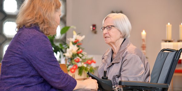 Eine Seelsorgerin unterhält sich mit einer Bewohnerin in der Kapelle des Seniorencentrums.